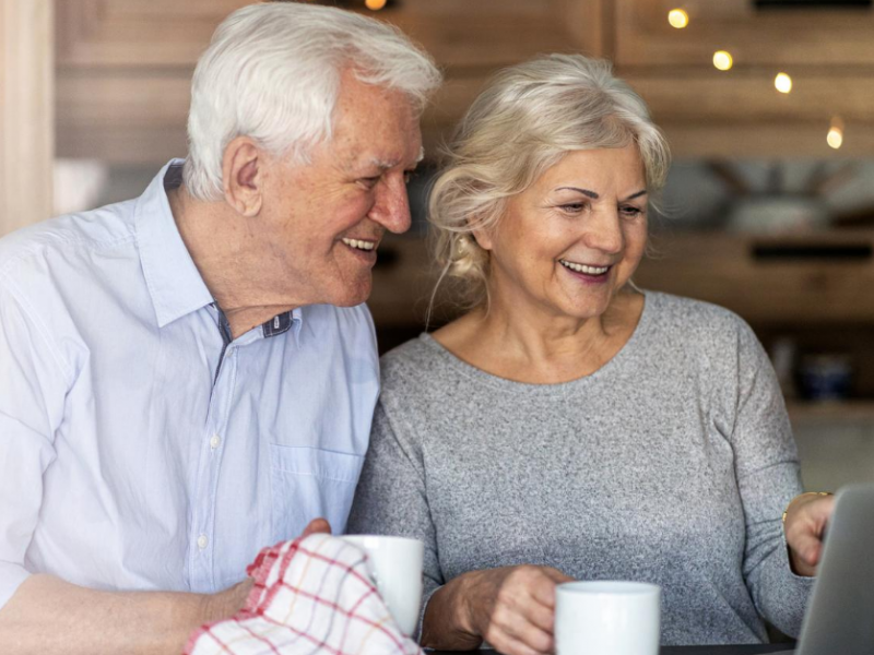 older couple smiling reading about a comfortable retirement